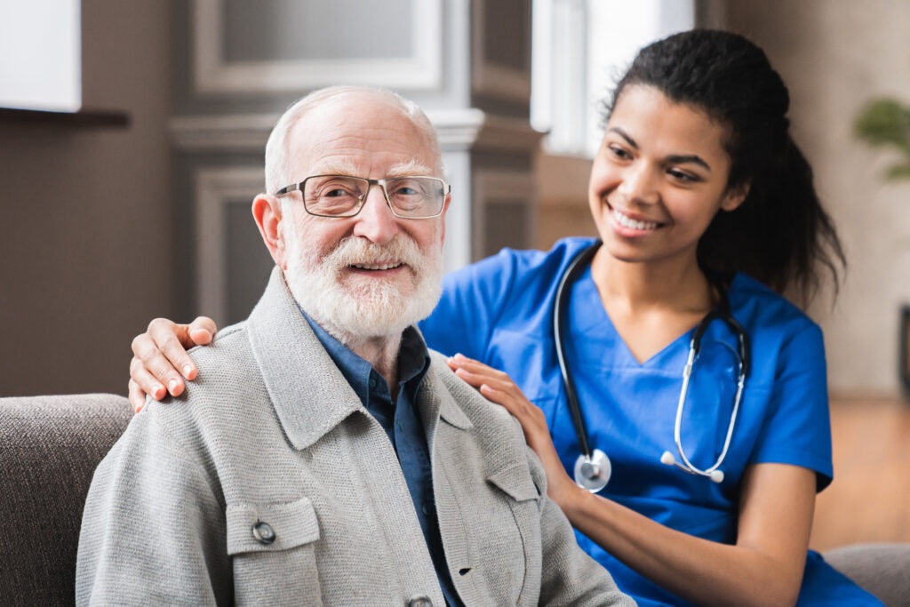young nurse in blue coat hugging old 80s man smili 2023 11 27 04 56 41 utc